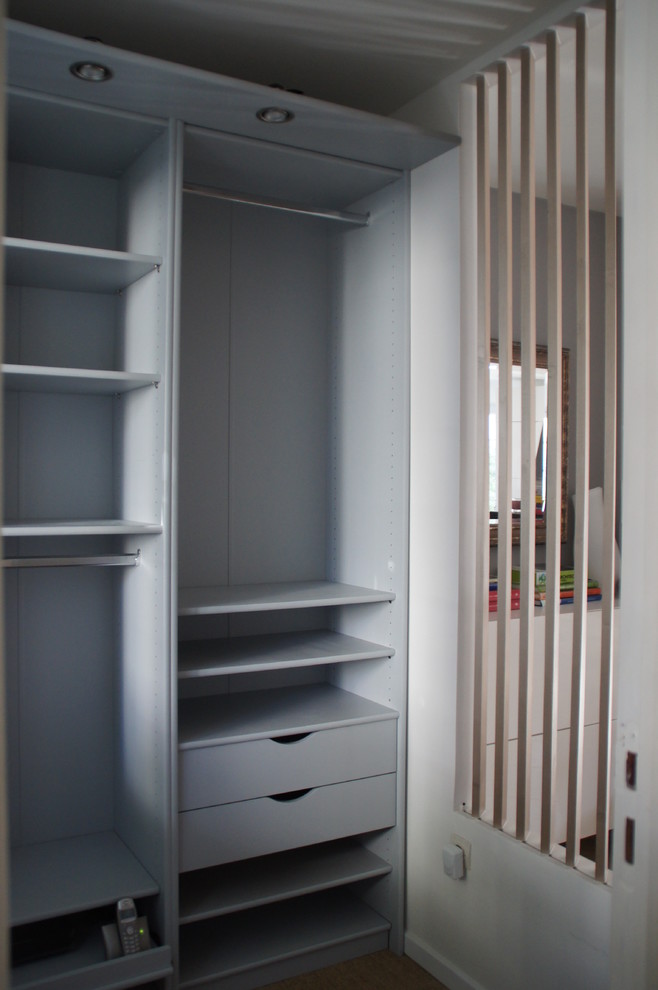 Inspiration for a mid-sized modern mudroom in Other with white walls, carpet and beige floor.
