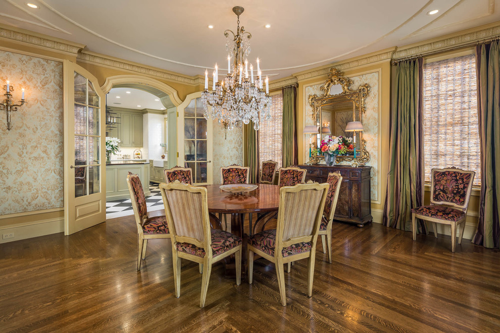This is an example of a traditional dining room in San Francisco with yellow walls, medium hardwood floors and brown floor.