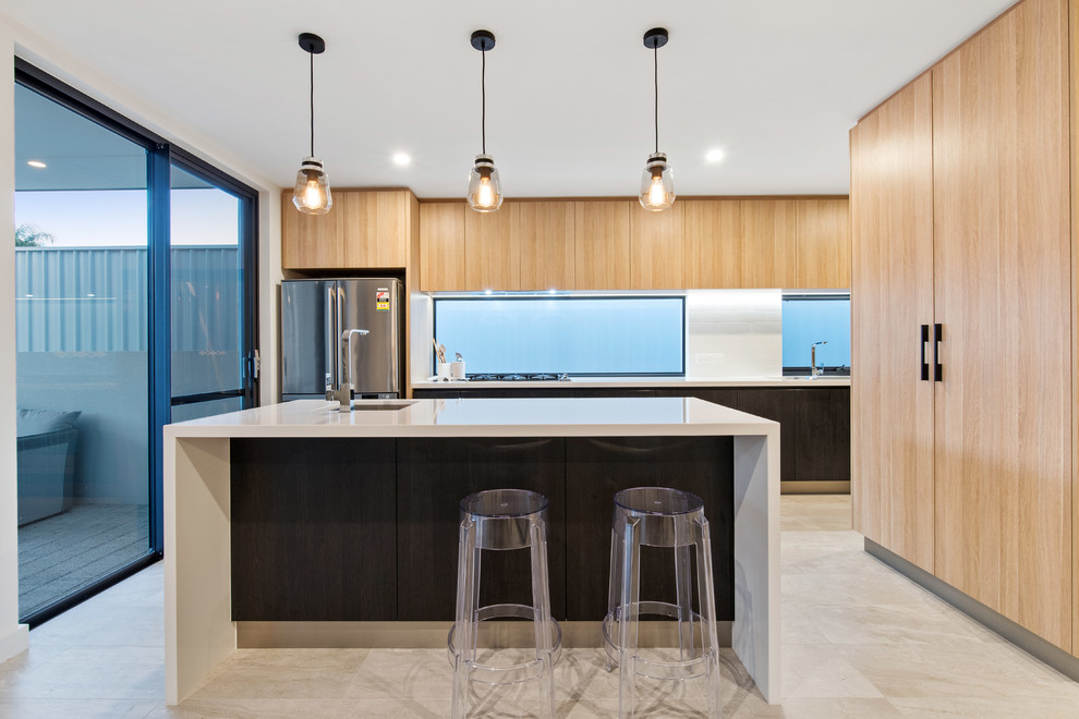 Inspiration for a contemporary kitchen in Perth with an undermount sink, flat-panel cabinets, light wood cabinets, white splashback, stainless steel appliances, with island, beige floor and white benchtop.