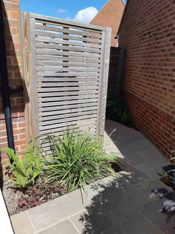 Idee per un piccolo privacy in giardino minimal dietro casa in estate con pavimentazioni in pietra naturale e recinzione in legno