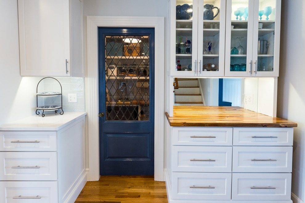 This is an example of an expansive traditional l-shaped eat-in kitchen in Providence with an undermount sink, recessed-panel cabinets, white cabinets, quartzite benchtops, blue splashback, porcelain splashback, stainless steel appliances, medium hardwood floors, with island and brown floor.