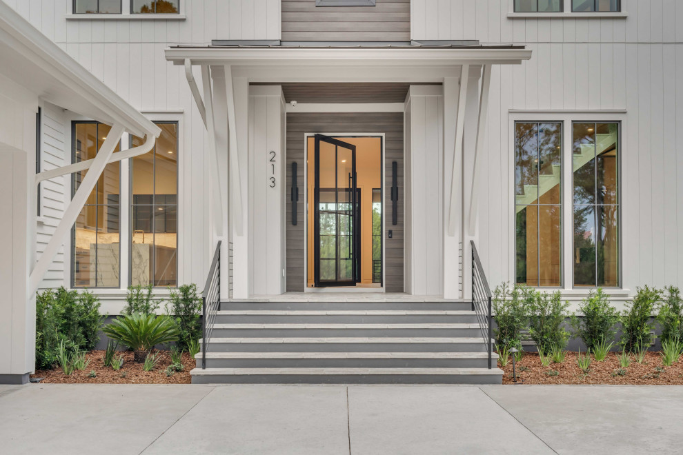 Inspiration for a traditional front door in Charleston with concrete flooring, a pivot front door, a black front door and grey floors.