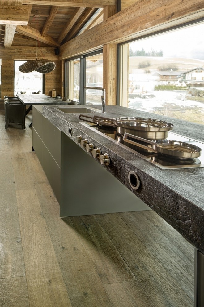 Mountain style medium tone wood floor kitchen photo with an island, wood countertops and gray backsplash