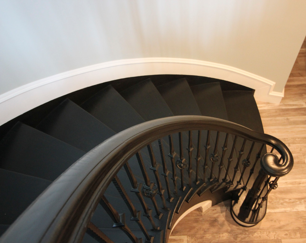 Photo of an expansive transitional wood curved staircase in DC Metro with wood risers and mixed railing.
