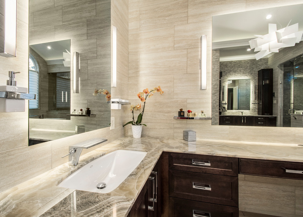 Large transitional master bathroom in Dallas with shaker cabinets, dark wood cabinets, a freestanding tub, a corner shower, beige tile, porcelain tile, beige walls, porcelain floors, an undermount sink and onyx benchtops.