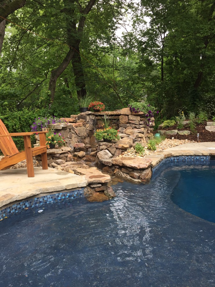 Example of a mid-sized mountain style backyard stone and custom-shaped pool fountain design in St Louis