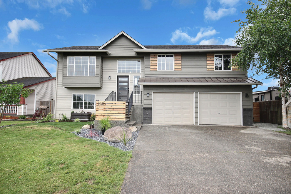 Example of a large country gray split-level wood house exterior design in Seattle with a mixed material roof