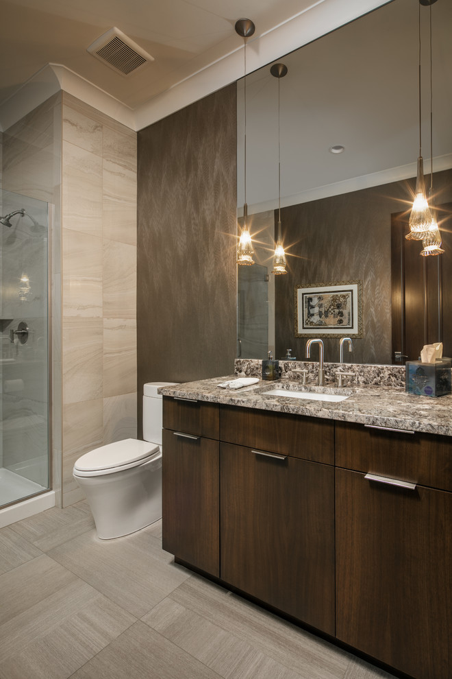 Alcove shower - mid-sized transitional 3/4 beige tile and porcelain tile porcelain tile and beige floor alcove shower idea in Omaha with flat-panel cabinets, dark wood cabinets, brown walls, an undermount sink, granite countertops and a hinged shower door