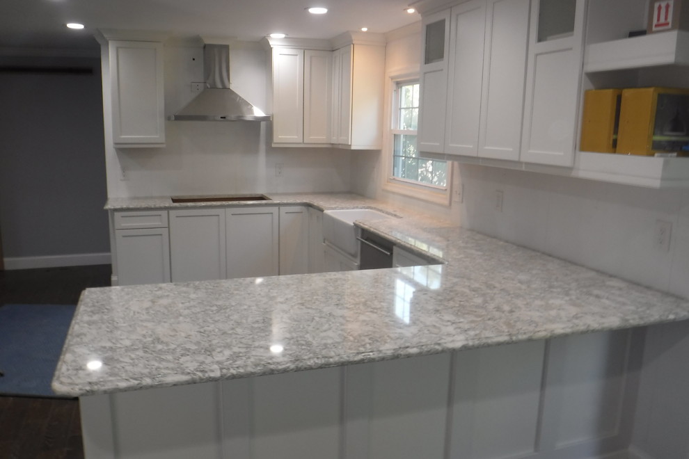 Inspiration for a mid-sized transitional u-shaped medium tone wood floor kitchen remodel in Baltimore with a farmhouse sink, shaker cabinets, white cabinets, quartz countertops, stainless steel appliances and a peninsula