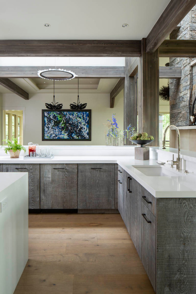 Kitchen - rustic light wood floor, brown floor and exposed beam kitchen idea with flat-panel cabinets, distressed cabinets, white backsplash, an island and white countertops