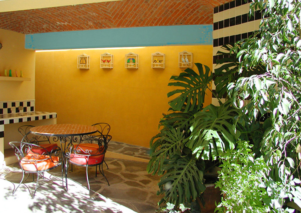 Inspiration for a mid-sized mediterranean courtyard patio in Austin with a container garden and a roof extension.