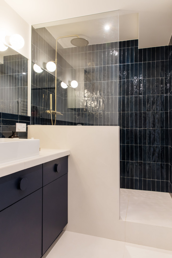This is an example of a small modern bathroom in Paris with blue tile, solid surface benchtops and a built-in vanity.
