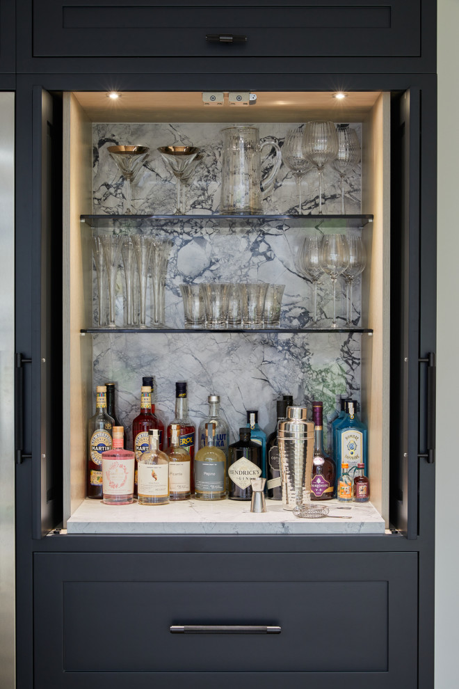 Design ideas for a large transitional l-shaped home bar in London with recessed-panel cabinets and black cabinets.