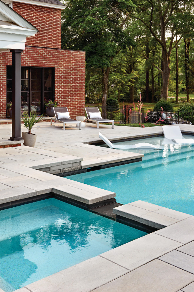 Large modern backyard rectangular lap pool in Philadelphia with a hot tub and concrete slab.
