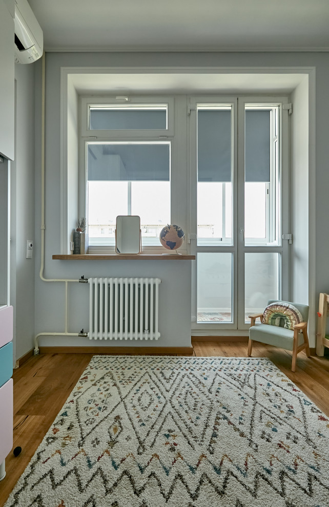 Imagen de dormitorio infantil de 4 a 10 años y blanco contemporáneo pequeño con paredes blancas y suelo de madera en tonos medios