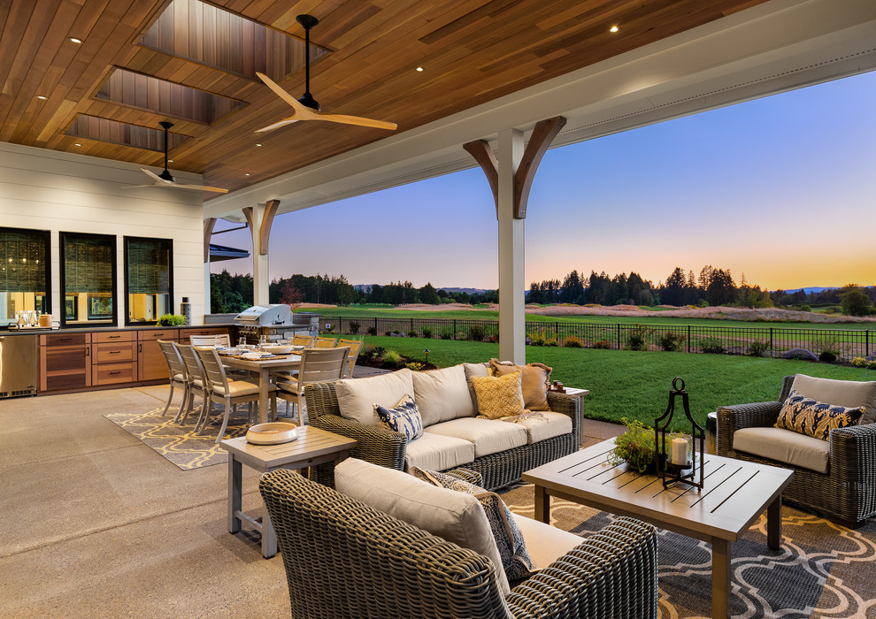 Photo of an expansive country backyard patio in Portland with concrete slab, a roof extension and an outdoor kitchen.