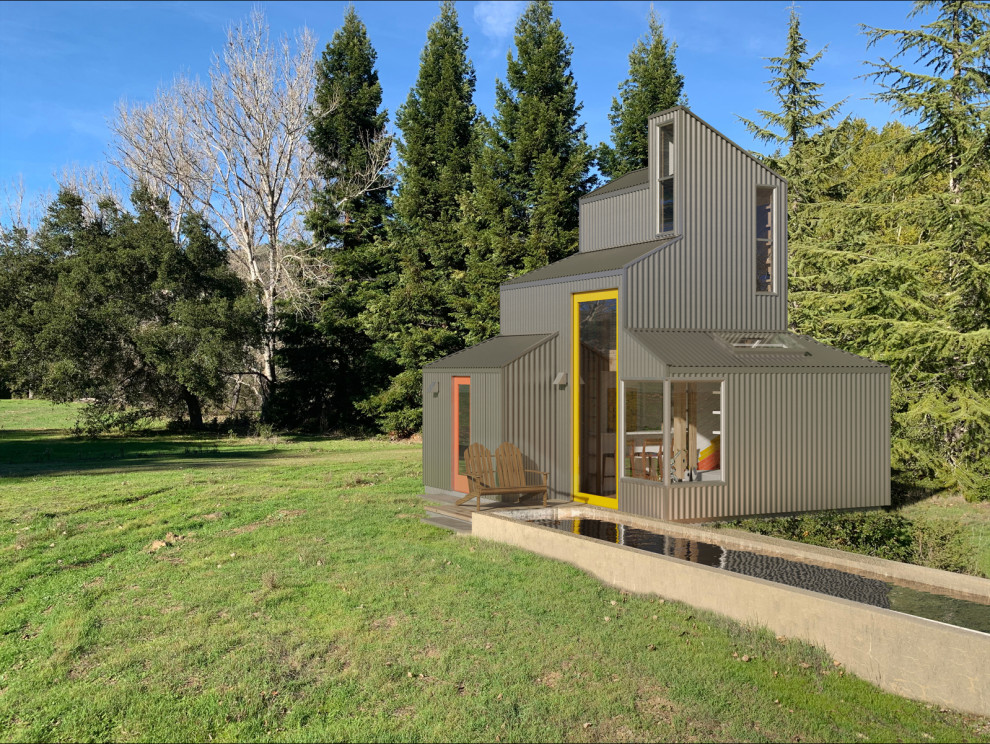 На фото: маленький мини дом в стиле шебби-шик с облицовкой из металла, двускатной крышей и металлической крышей для на участке и в саду, охотников с