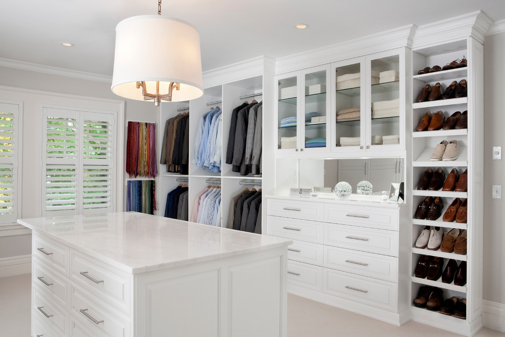 Photo of a large contemporary gender-neutral walk-in wardrobe in New York with white cabinets, carpet and raised-panel cabinets.
