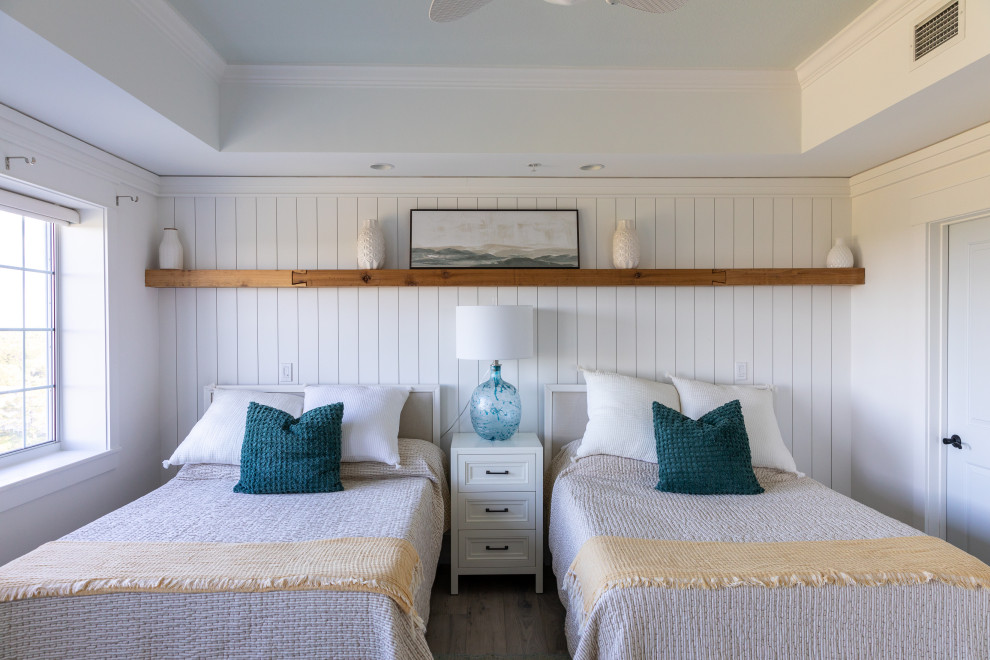 他の地域にある中くらいなビーチスタイルのおしゃれな主寝室 (白い壁、無垢フローリング、木材の暖炉まわり、グレーの床、折り上げ天井、塗装板張りの壁)