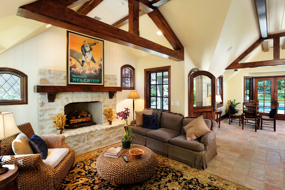 This is an example of an expansive traditional open concept living room in San Francisco with a stone fireplace surround, yellow walls, terra-cotta floors and a standard fireplace.