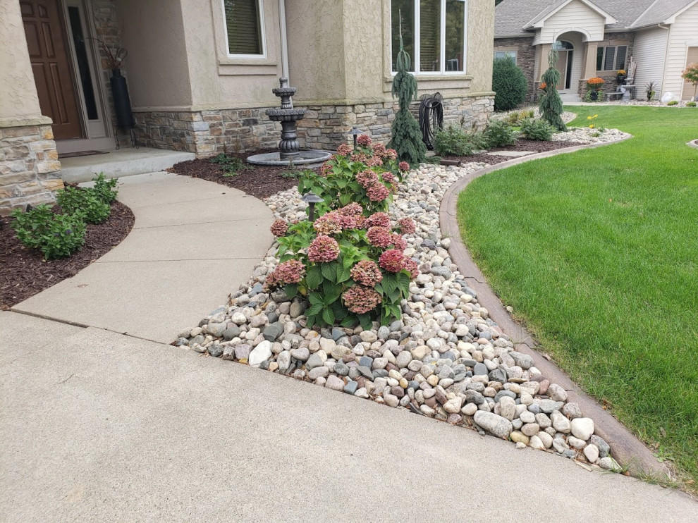 Design ideas for a transitional front yard garden in Minneapolis with with flowerbed and river rock.