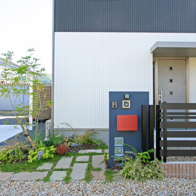 北欧風ポストが映えるモダンな門柱に 天然石や植栽でナチュラルさをプラスしたエクステリア Moderno Fachada Otras Zonas De 匠ガーデン