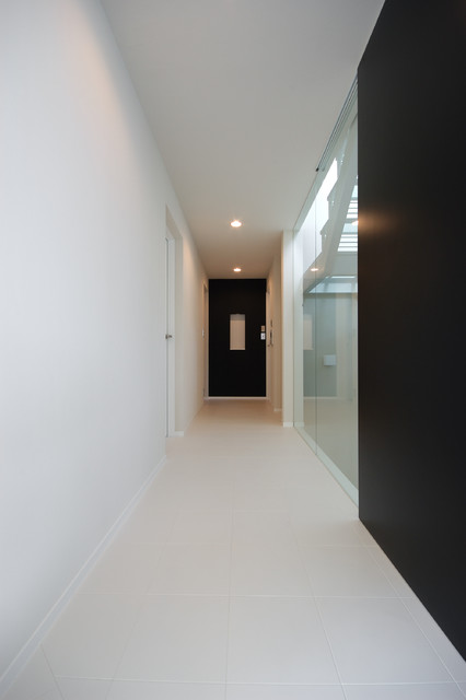 2階子世帯の廊下です 奥には飾り棚 階段室との仕切りはガラスのカーテンです 白にワンポイントで色を添えています Moderno Recibidor Y Pasillo Tokio De 下田設計 Houzz