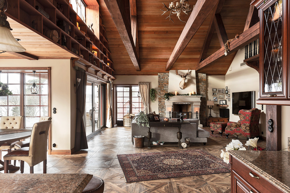 Modelo de sala de estar abierta rural grande con paredes beige y suelo marrón