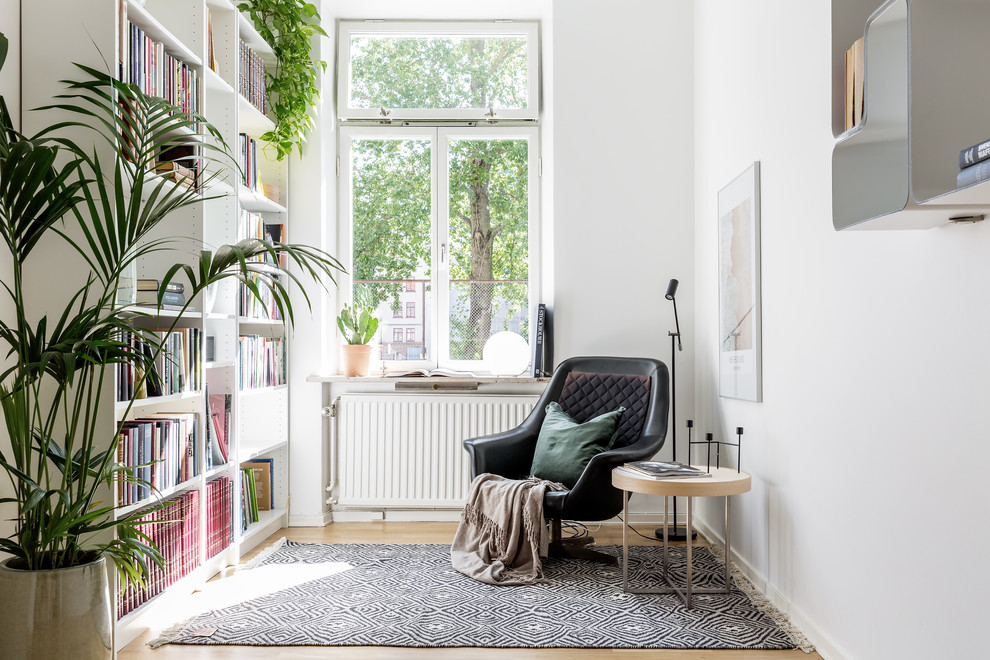 Aménagement d'une salle de séjour scandinave avec un mur blanc, parquet clair et un sol beige.
