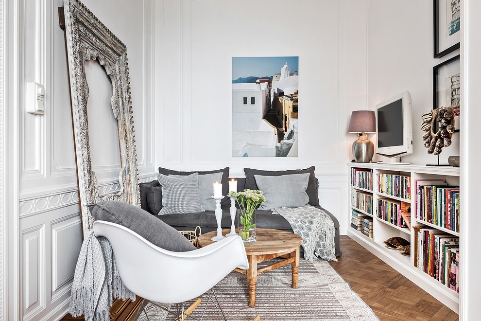 Источник вдохновения для домашнего уюта: изолированная гостиная комната в скандинавском стиле с белыми стенами, паркетным полом среднего тона, отдельно стоящим телевизором и коричневым полом