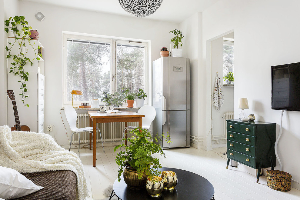 Family room - mid-sized scandinavian open concept painted wood floor family room idea in Stockholm with white walls and no tv