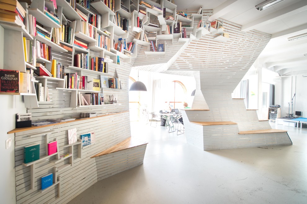 Idee per un soggiorno nordico con libreria, pareti bianche, pavimento in cemento, nessun camino e pavimento grigio