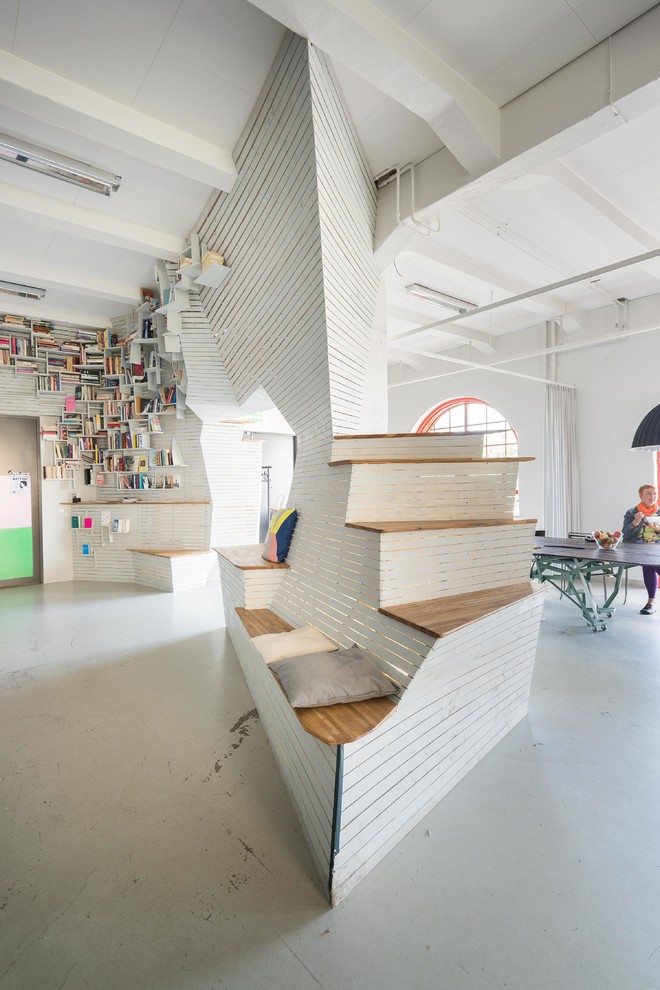 Idéer för ett stort skandinaviskt allrum med öppen planlösning, med ett bibliotek, vita väggar, betonggolv och grått golv