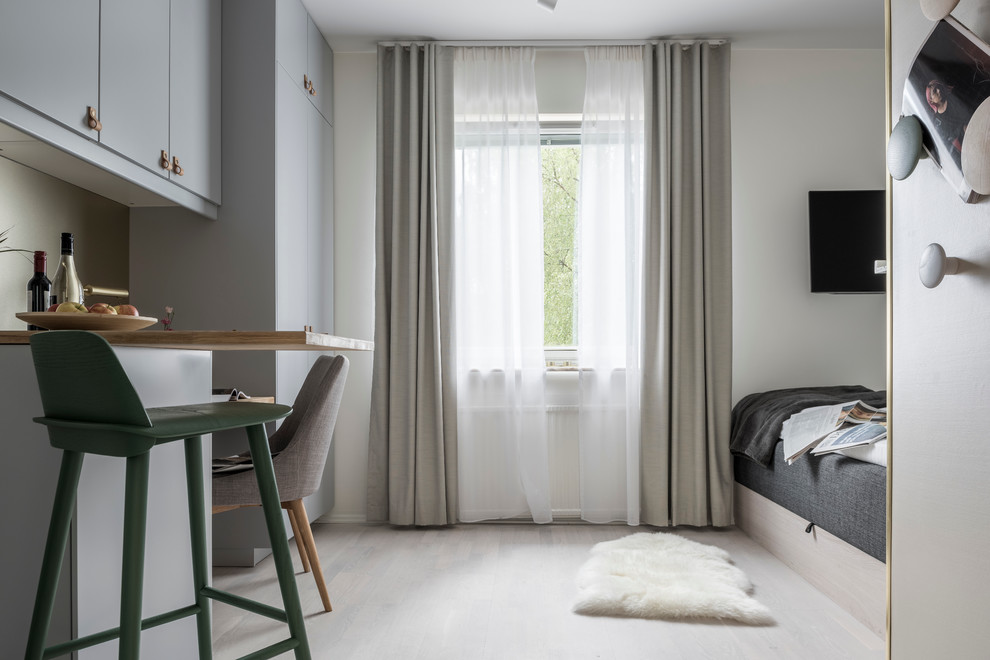 Diseño de sala de estar abierta nórdica pequeña con paredes beige y suelo de madera clara