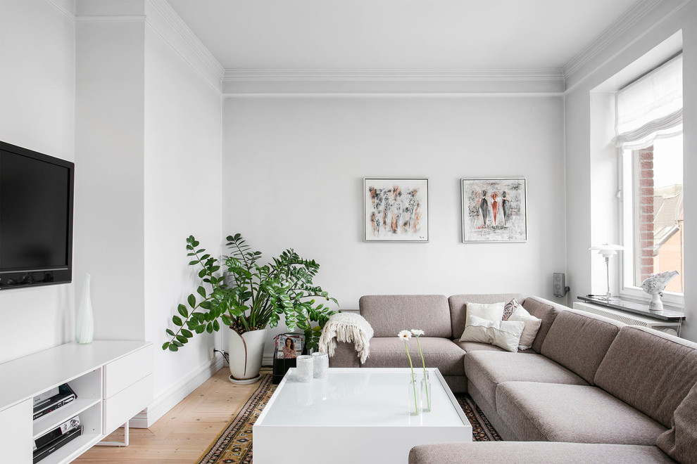 Inspiration för mellanstora skandinaviska allrum, med vita väggar, ljust trägolv och en väggmonterad TV