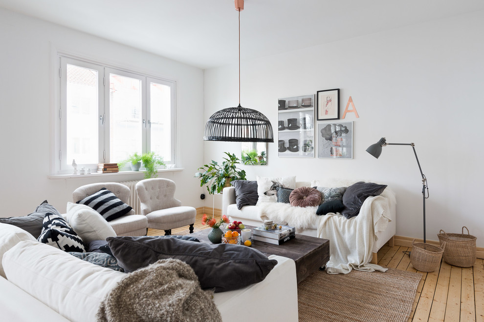 На фото: открытая гостиная комната среднего размера в скандинавском стиле с белыми стенами и светлым паркетным полом с