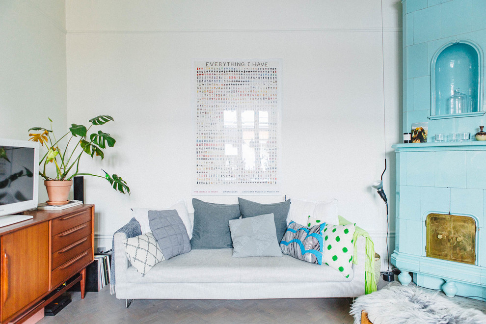 Idéer för mellanstora minimalistiska allrum, med vita väggar, en öppen hörnspis, en fristående TV och ljust trägolv