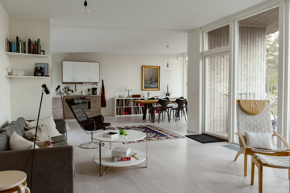This is an example of a large scandi open plan games room in Stockholm with white walls and beige floors.