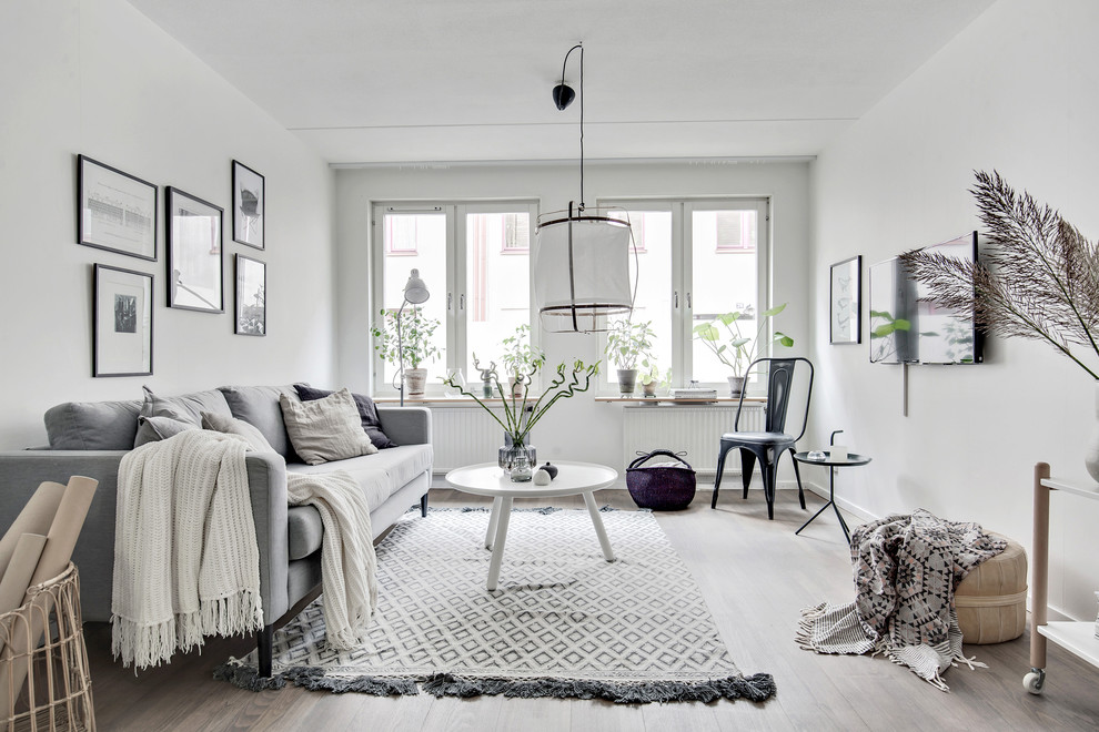 Example of a mid-sized danish enclosed light wood floor and beige floor family room design in Gothenburg with white walls