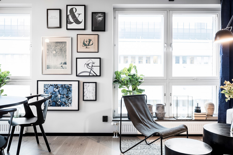 Foto de sala de estar abierta escandinava grande sin chimenea y televisor con paredes blancas, suelo de madera clara y suelo gris