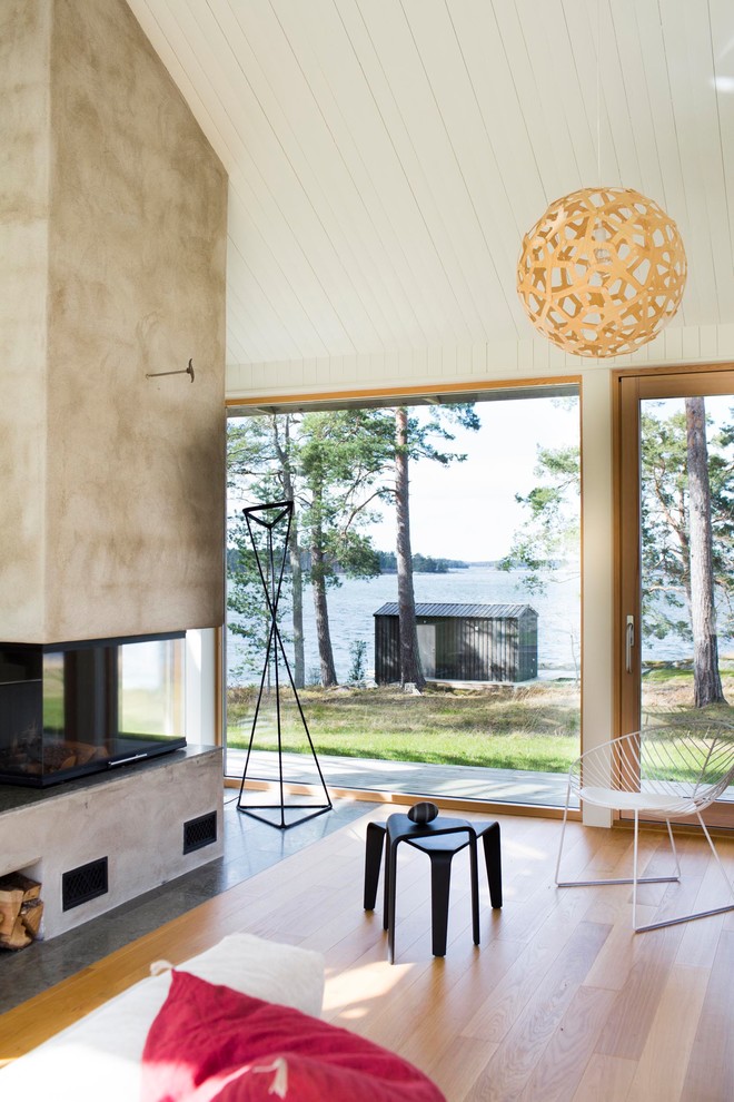 Источник вдохновения для домашнего уюта: открытая гостиная комната в скандинавском стиле с белыми стенами, паркетным полом среднего тона, горизонтальным камином, фасадом камина из бетона и разноцветным полом