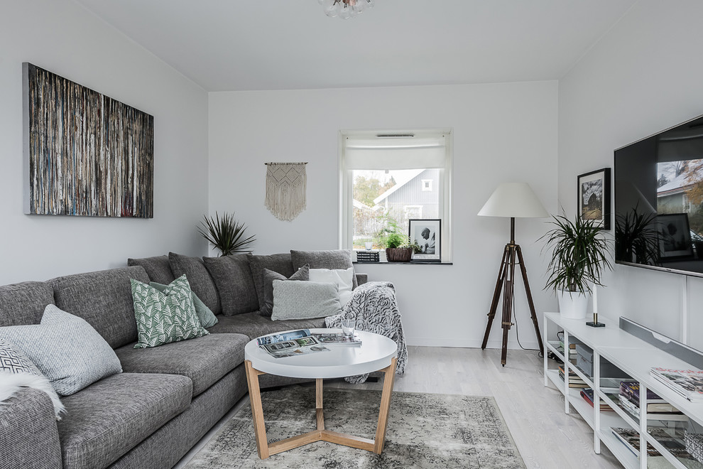 Идея дизайна: маленькая изолированная гостиная комната в скандинавском стиле с белыми стенами, светлым паркетным полом, телевизором на стене и серым полом для на участке и в саду