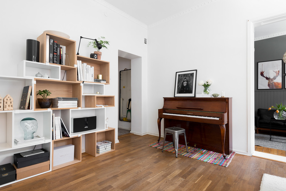 Diseño de sala de estar abierta nórdica grande con paredes blancas y suelo de madera en tonos medios