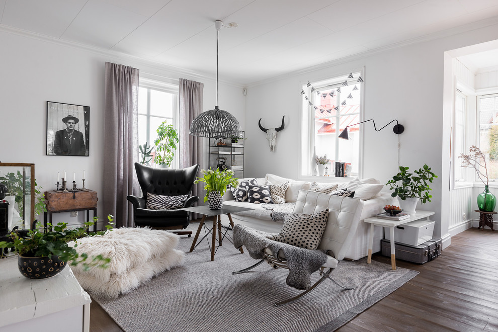 Diseño de salón escandinavo con paredes blancas, suelo de madera oscura y suelo marrón