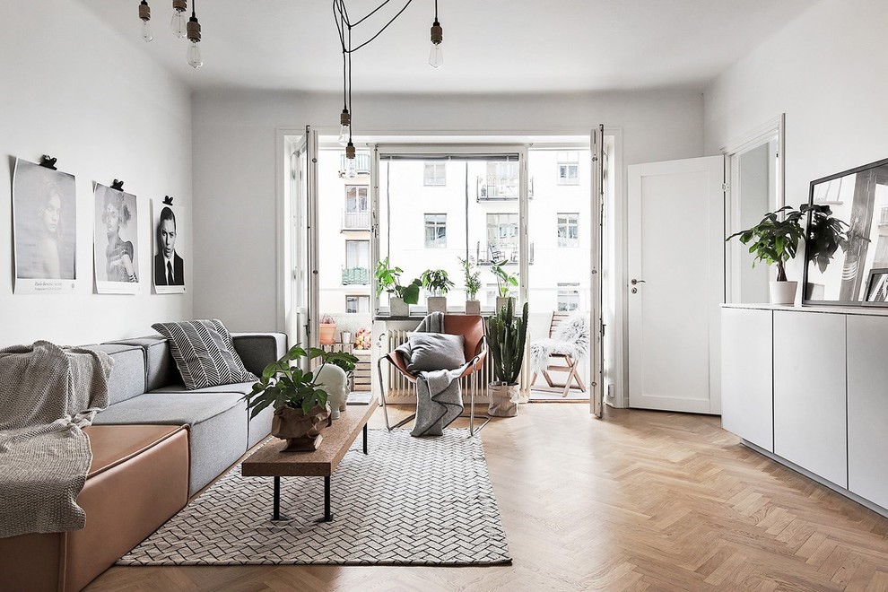 Mid-sized danish open concept medium tone wood floor family room photo in Stockholm with white walls, no fireplace and no tv