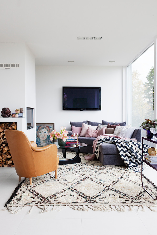 Modelo de sala de estar abierta escandinava de tamaño medio con paredes blancas, televisor colgado en la pared y suelo de piedra caliza