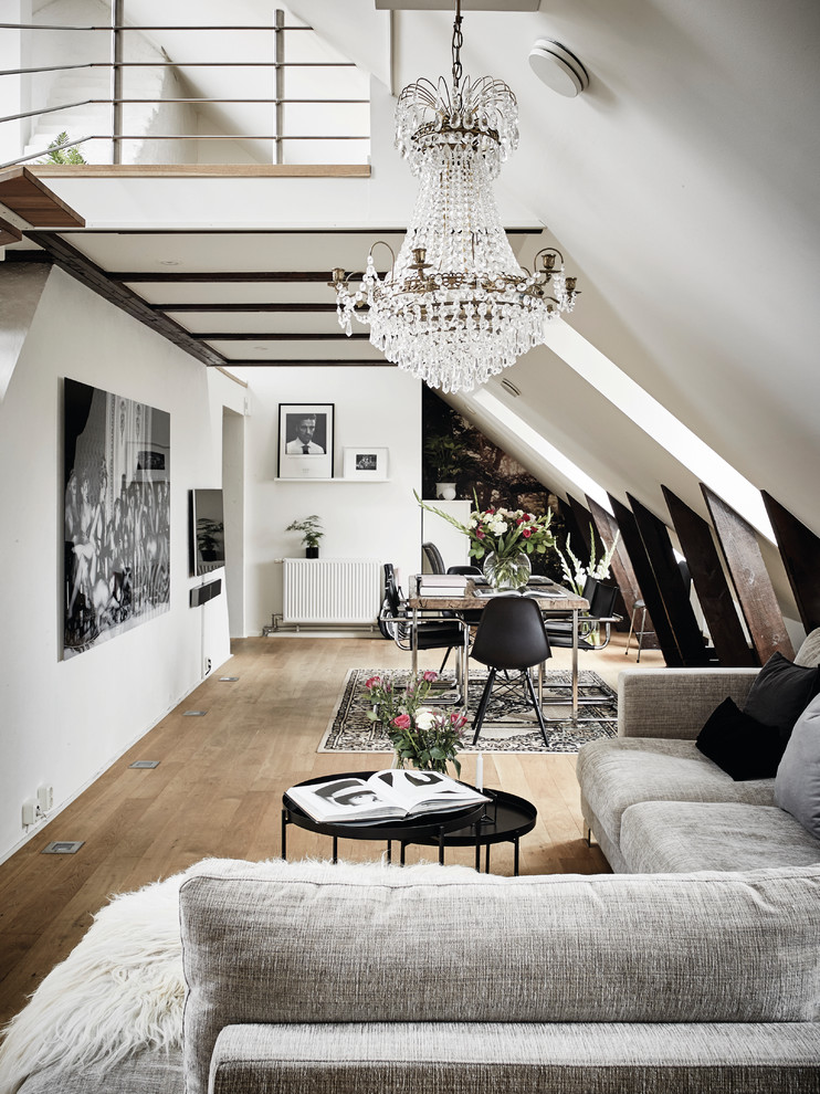 Expansive scandi open plan games room in Gothenburg with white walls, light hardwood flooring and a wall mounted tv.