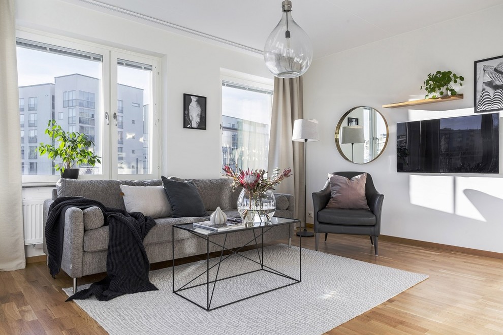 Imagen de sala de estar escandinava de tamaño medio con paredes blancas y televisor colgado en la pared