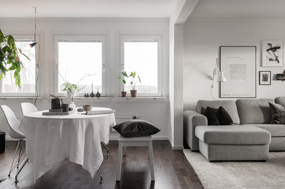 Mittelgroßes Nordisches Wohnzimmer mit weißer Wandfarbe, dunklem Holzboden und braunem Boden in Stockholm