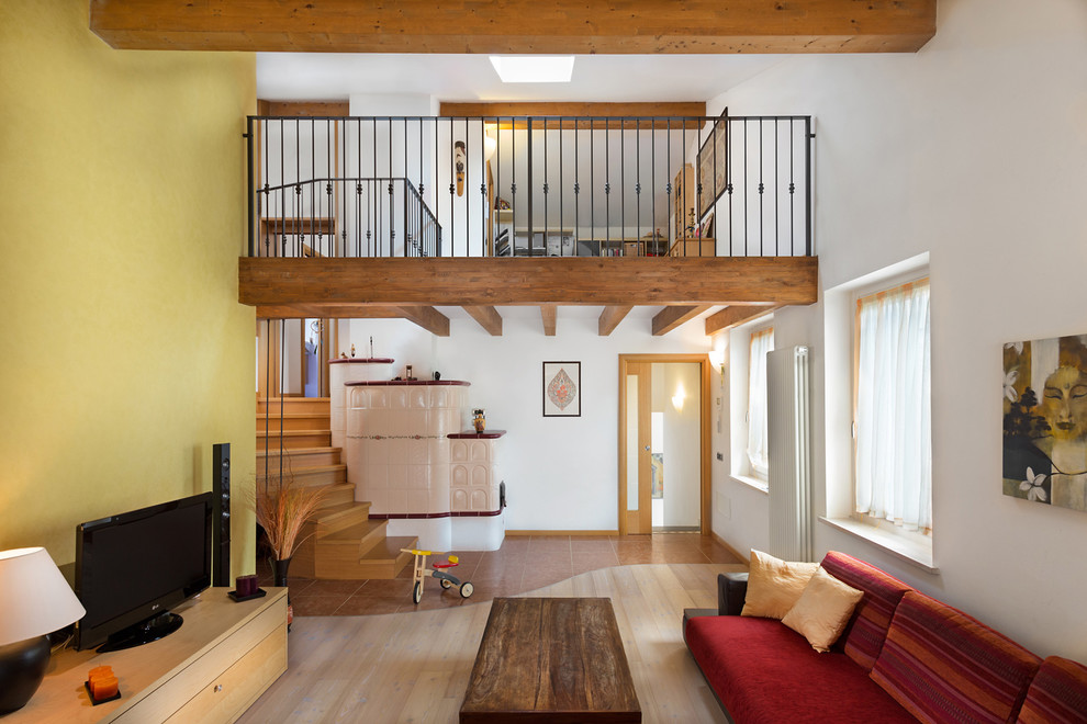 Mittelgroßes, Offenes Mediterranes Wohnzimmer ohne Kamin mit bunten Wänden, hellem Holzboden, freistehendem TV und beigem Boden in Stockholm